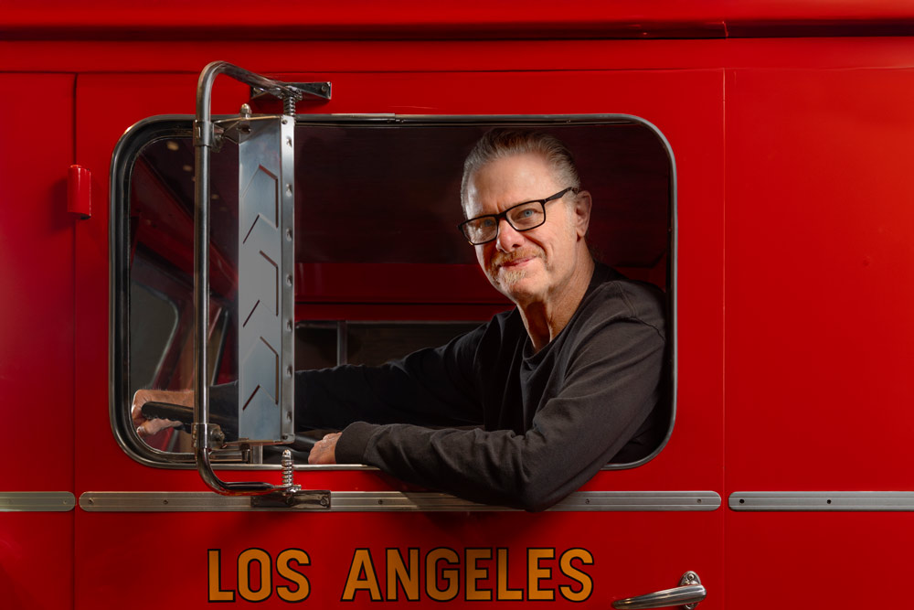 Retired firefighter Ken Cochran smiles from the driver's seat of a vintage fire engine